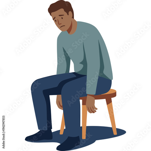 A man sits on a chair looking down with sadness and disappointment