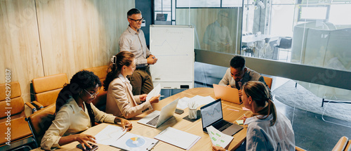 White leader negotiating contract with black colleague in executive meeting