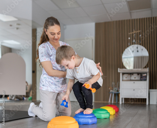 Pediatric Therapist Helping Young Boy Balance on Colorful Stepping Stones During Play Therapy Session