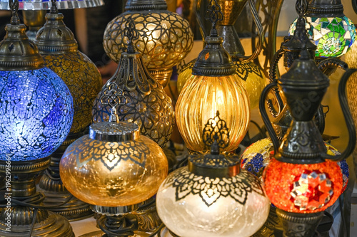 A colorful collection of glass lanterns with mosaic patterns is on display