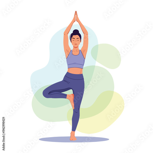 A woman in athletic wear practices the tree pose during yoga