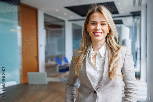 Confident businesswoman smiling in a modern office, representing professional success and corporate leadership