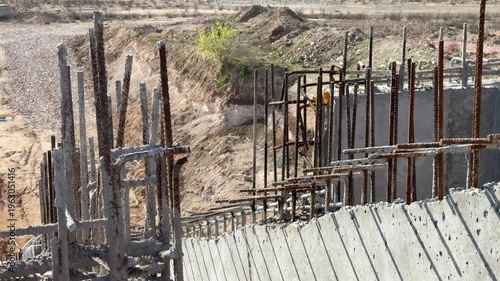Concrete foundations with rusty rebar preparing for new wall construction