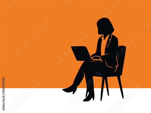 Silhouette of a businesswoman sitting and working on a laptop