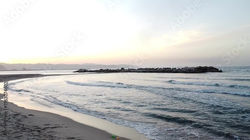 Stunning aerialdrone shot of sunset over a Mediterranean beach in Algeria,  calm waves, and a golden horizon.