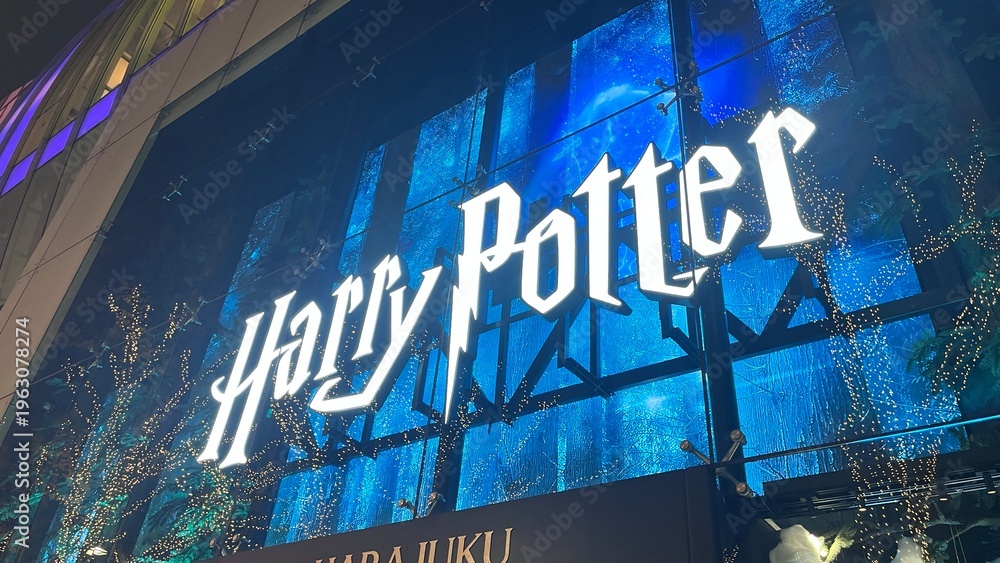 Naklejka premium Harry Potter promotional display with an illuminated logo and magical theme at the Zara Harajuku-ten store facade in Shibuya - Tokyo, Japan, December 13, 2025