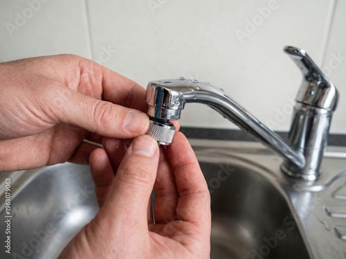 Hands installing faucet aerator to reduce water demand and improve household efficiency in sustainable home retrofit