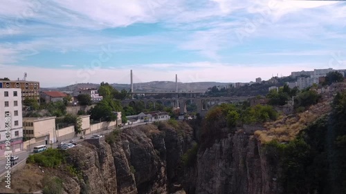 Scenic aerial view of the historic Sidi Rached Viaduct and the modern Salah Bey Bridge spanning the deep Rhumel River gorge in Constantine, Algeria.