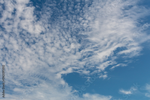 A clear blue sky with transparent white clouds.