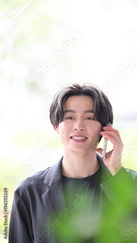 電話対応をする若い男性ビジネスマンの信頼感ある営業や連絡の相談などの顧客対応、サポートの上半身のビジネスシーンのコミュニケーションの縦動画