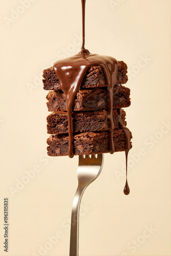 Melted Chocolate Sauce Pouring over Stack of Chocolate Chip Brownie Squares on a Fork