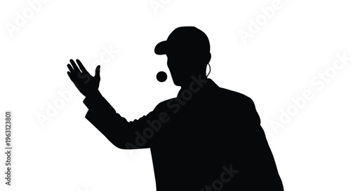 Silhouette of a man in a baseball cap gesturing with his hand and wearing a headset
