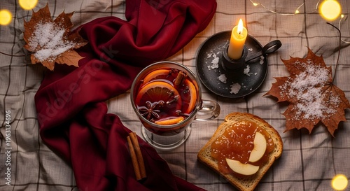 Cozy autumn scene features a mug of mulled wine next to toast with jam, illuminated by a warm candlelight and scattered fallen leaves.