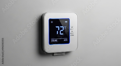 Modern digital thermostat on wall.
