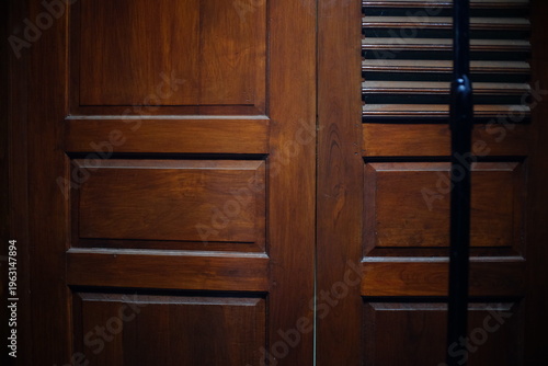 Dark brown wooden door with a polished varnish are used for traditional, classic, or retro themed visual backgrounds.