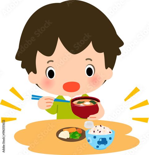 ご飯と漬物と味噌汁の食事を摂る男の子