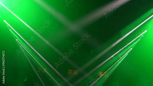 Bright green spotlights cut through the dark atmosphere of an empty stage or venue. The dynamic beams create circular patterns on the floor, evoking an energetic mood for a concert or live event.

