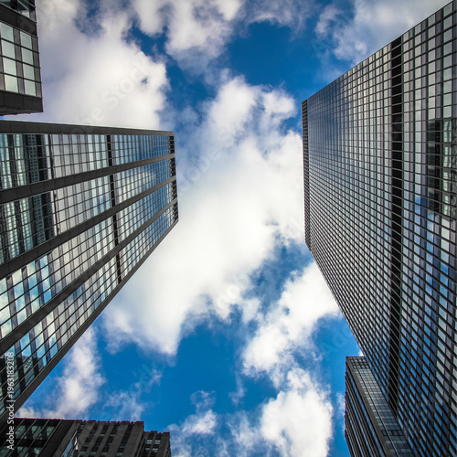 Modern Skyscrapers Reaching for a Bright Blue Sky with Clouds