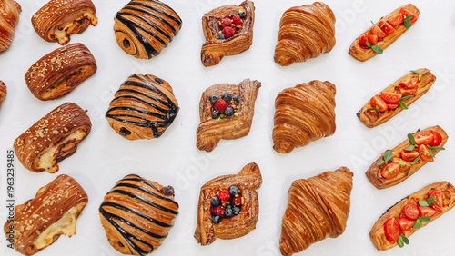 Assorted bakery pastries and croissants arranged on a white table for breakfast and brunch