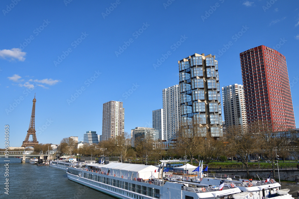 Obraz premium Eiffel Tower and riverside buildings seen from the Seine near Pont de Grenelle, Paris, France, March 15, 2026