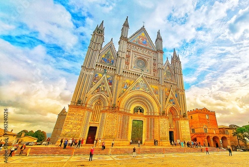 Canvas-taulu Magnificent Gothic Facade of Orvieto Cathedral (Duomo di Orvieto) with golden Mosaics and tourists under cloudy blue sky
