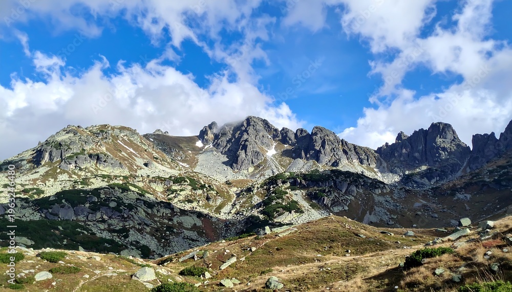 Fototapeta premium Majestic Mountain Range Under a Cloudy Blue Sky.