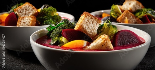 Hearty Beetroot Soup with Croutons and Greens in White Bowls.