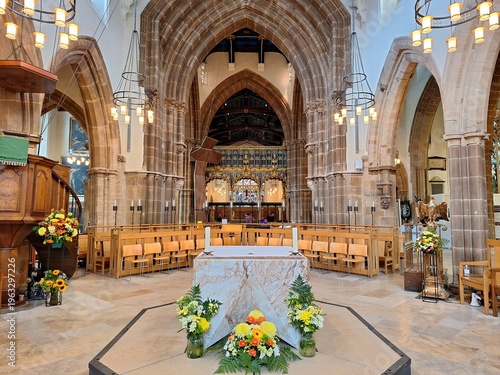 Obraz na płótnie The central nave of Leicester Cathedral in England showcases soaring Gothic arches, warm sandstone columns, and a contemporary marble altar positioned beneath elegant circular chandeliers