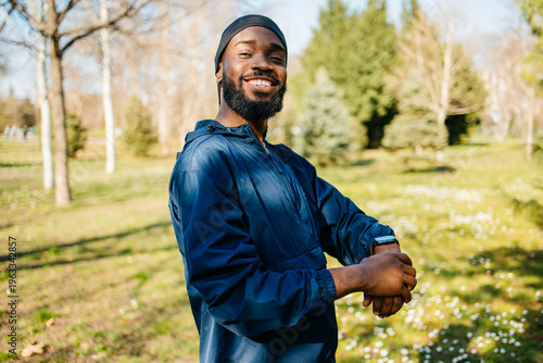 фотографія A young male African American athlete is standing in the park and going for a ru