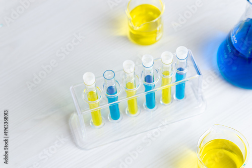 Top view of colorful chemical samples in test tubes with blue and yellow liquids, laboratory experiment and science research concept