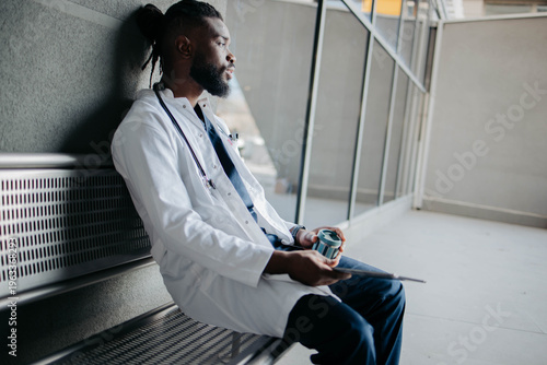 Tableau sur toile Tired medical worker sitting in front of the hospital
