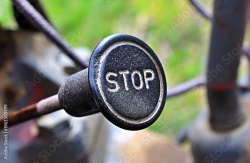 Close up of a black vintage stop pull knob on tractor machinery.