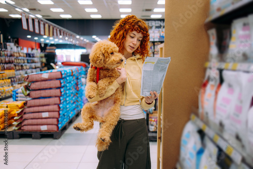Cuadro en lienzo Happy woman buying a leash at a pet shop