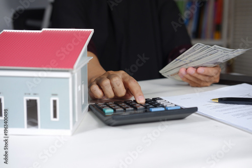 Konstfotografi Clicking on a calculator, the model house is either buy or rent