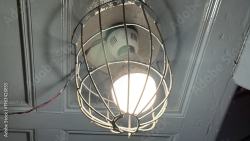 Vintage Industrial Cage Light Fixture Glowing Brightly