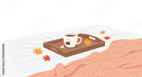 A steaming cup of tea on a wooden tray with scattered autumn leaves rests on a white bedsheet next to a peach-colored knitted blanket.