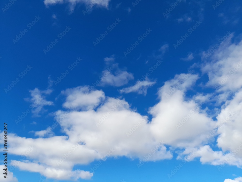 Fototapeta premium Beautiful bright blue sky with fluffy white cumulus clouds on a sunny day