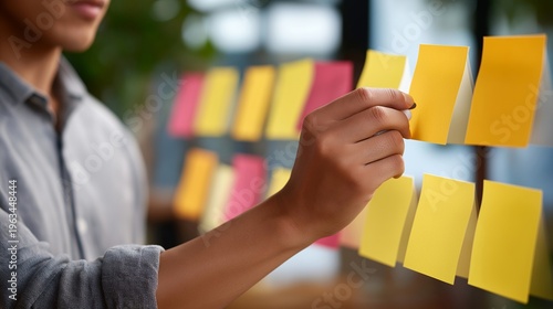 Close up hands arranging customer feedback sticky notes on large wall chart, categorizing pain points discovered during street interviews for subscription box startup validation research phase,