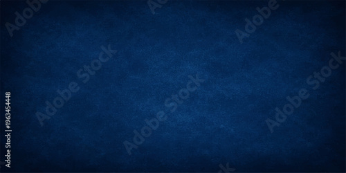 A dark blue grunge background with a vintage textured pattern featuring a dirty denim fabric material and old paper wall design for a moody textile backdrop