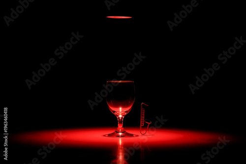 Jazz Bar Empty wine glass and saxophone charm illuminated by red light image