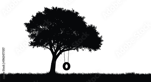 A solitary tree with a tire swing against a bright sky silhouette