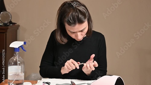 Young woman doing manicure at home