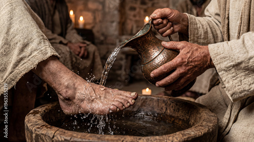 Man washing another man's feet in traditional setting with candles  