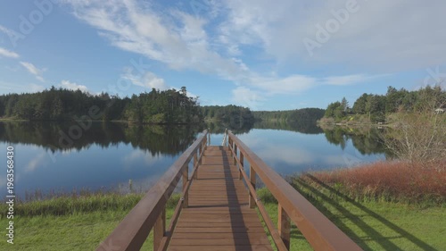 Time lapse shot of clouds moving over dock at lake.