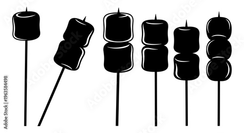 Collection of black silhouette marshmallows on sticks for roasting or baking