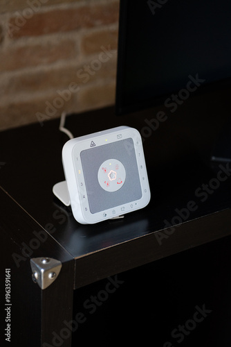 Telecare medical alert system with a glowing red button on a dark table, providing home safety and peace of mind for seniors and independent living at home