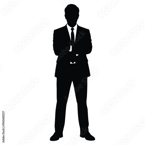A sharply dressed man in a suit and tie stands confidently a striking silhouette