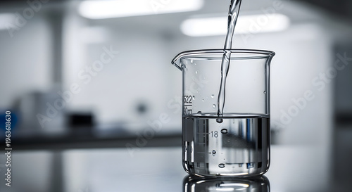 Laboratory beaker being filled with clear liquid