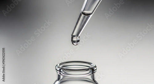 A single dropper dropping liquid into a small glass bottle