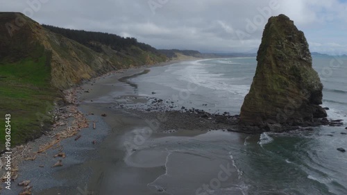 Aerial view of Oregon coast with large rock in ocean waves